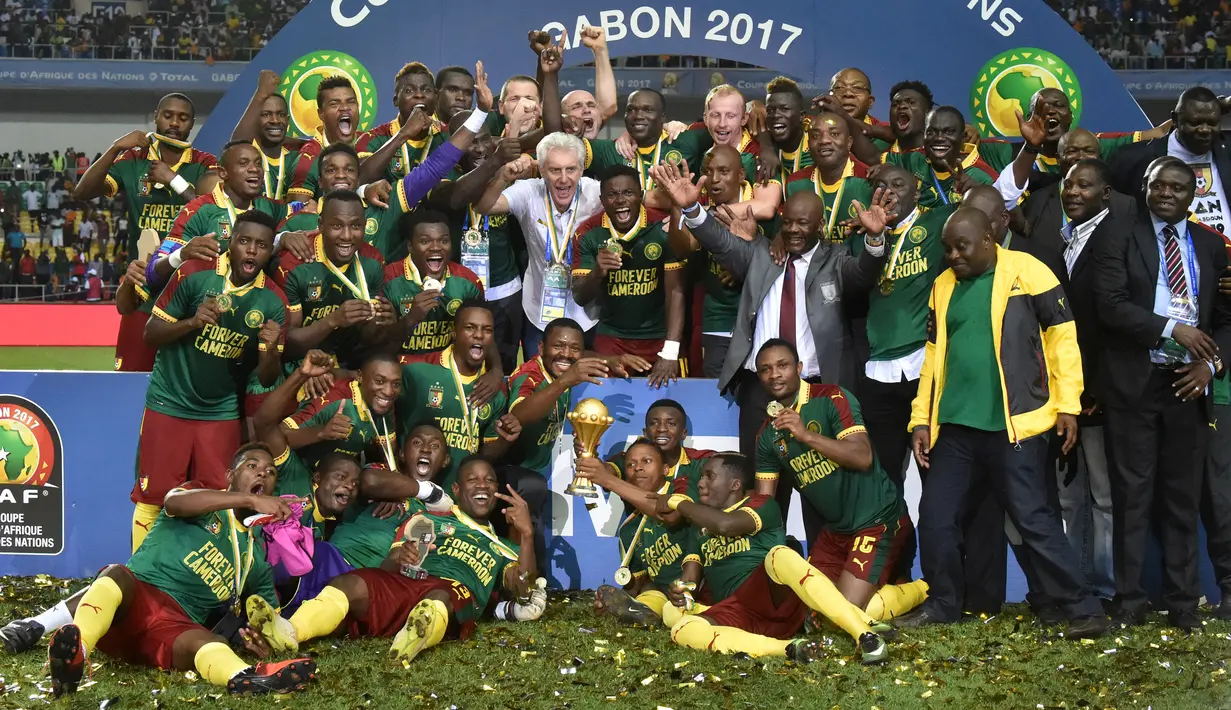 Pemian Kamerun bersama pelatihnya, Hugo Broos berfoto bersama sambil merayakan kemenangan pada laga final Piala Afrika 2017 di Stade de I'Amitie, Gabon, Minggu (5/2). Kamerun meraih gelar kelima Piala Afrika usai menang 2-1 atas Mesir. (GABRIEL BOUYS/AFP)