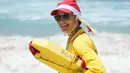 Seorang penyelamat mengenakan topi Santa sambil mengawasi orang-orang yang berkumpul di Pantai Bondi untuk merayakan Natal di Sydney, Sabtu