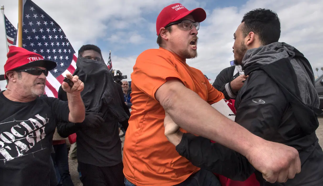 Ekspresi pendukung Presiden Donald Trump saat bentrok dengan pengunjuk rasa anti-Trump di Huntington Beach, California (25/3). (Mindy Schauer / The Orange County Register via AP)
