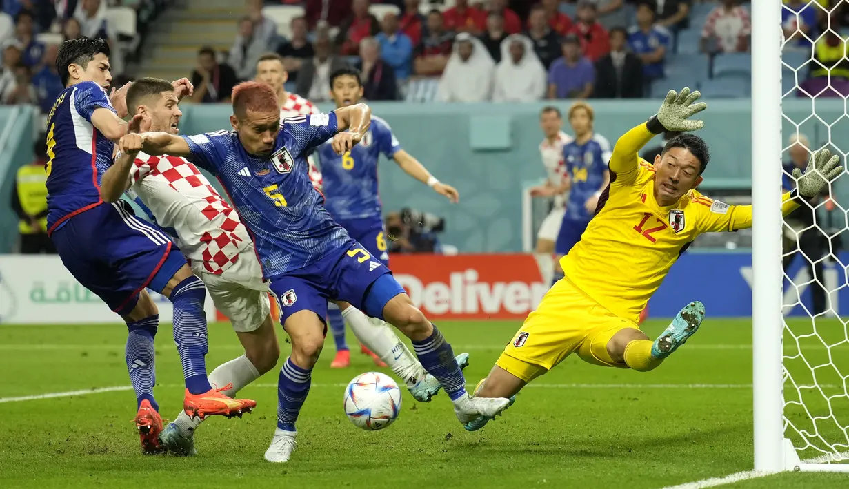 <p>Kiper Jepang,&nbsp;Shuichi Gonda (kanan) berusaha menghalau bola saat laga 16 besar Piala Dunia 2022 melawan Kroasia di Al Janoub Stadium, Senin (05/12/2022). (AP/Francisco Seco)</p>