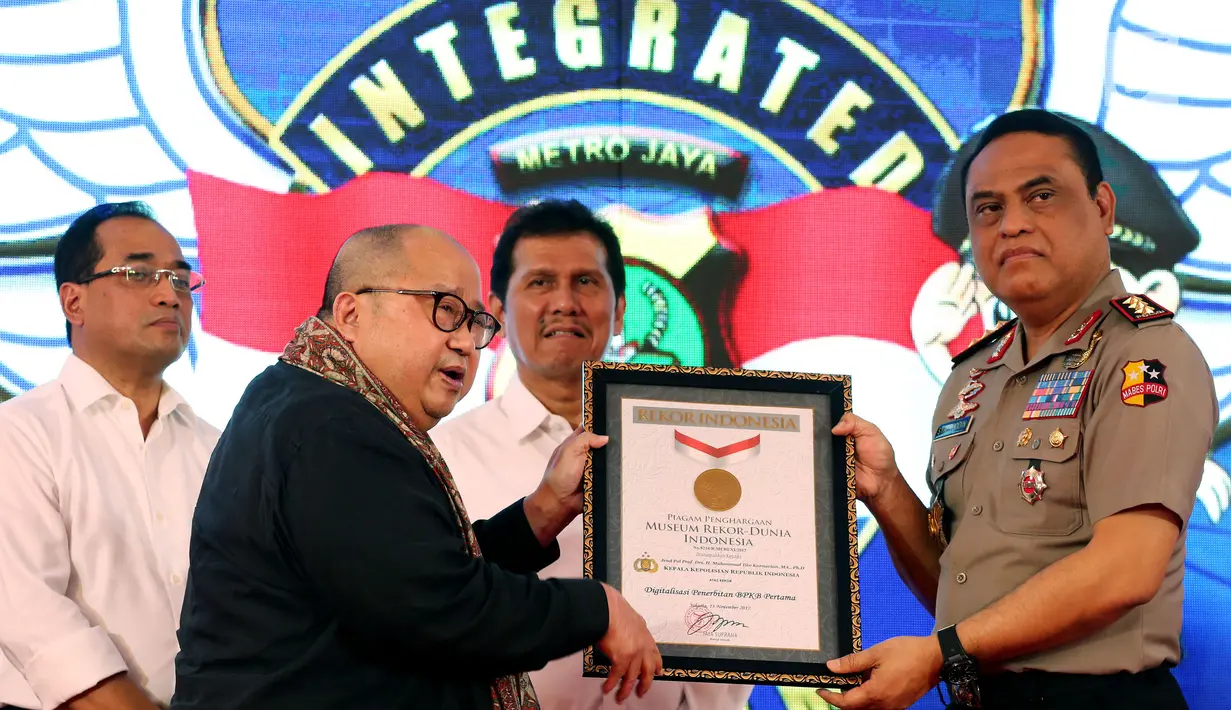 Wakalolri Komjen Syafruddin menerima penghargaan MURI kategori Digitalasasi Penerbitan BPKB Pertama dari Ketua Rekor MURI, Jaya Suprana saat peluncuran BPKB berbasis online atau e-BPKB di Polda Metro Jaya, Senin (13/11). (Liputan6.com/Johan Tallo)