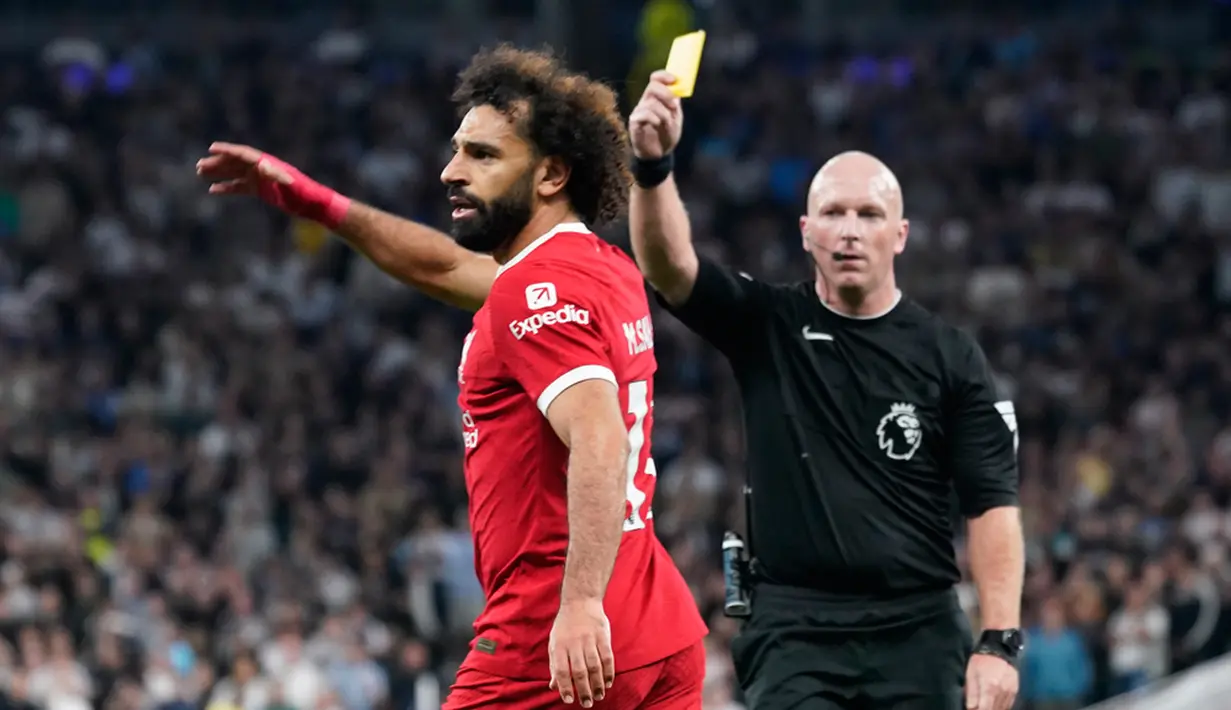 Wasit Simon Hooper memberikan kartu kuning kepada pemain Liverpool Mohamed Salah saat pertandingan sepak bola Liga Inggris antara Tottenham Hotspur dan Liverpool di Tottenham Hotspur Stadium, London, Inggris, Sabtu (30/9/2023). Tottenham Hotspur mengalahkan Liverpool dengan skor 2-1. (AP Photo/Alberto Pezzali)