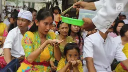 Pemuka agama Hindu memberikan air suci saat upacara Tawur Kesanga di Pura Aditya Jaya, Rawamangun, Jakarta, Jumat (16/3). (Liputan6.com/Arya Manggala)