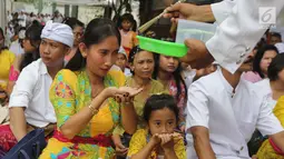 Pemuka agama Hindu memberikan air suci saat upacara Tawur Kesanga di Pura Aditya Jaya, Rawamangun, Jakarta, Jumat (16/3). (Liputan6.com/Arya Manggala)