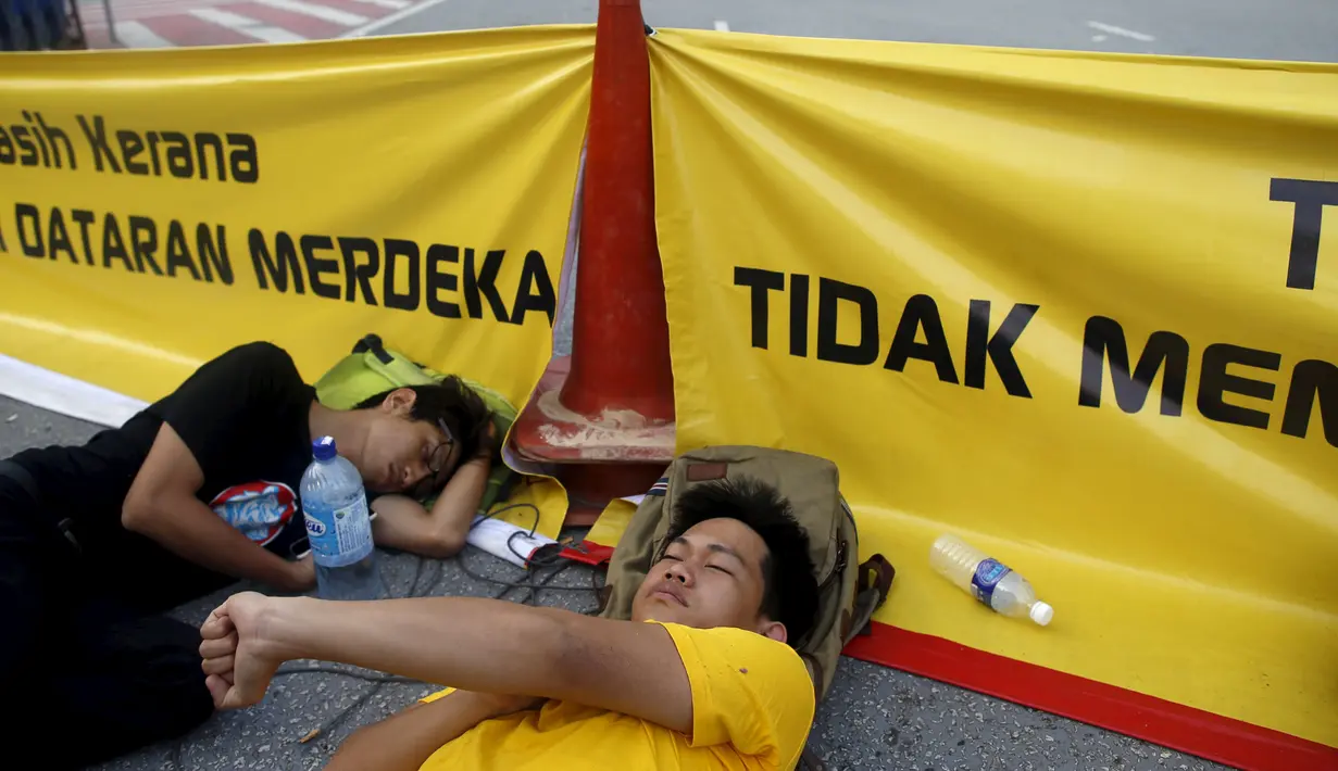 Kelompok aliansi pro-reformasi tidur di dekat spanduk saat aksi gerakan Bersih 4.0 di ibukota Malaysia, Kuala Lumpur, Minggu (30/8/2015). Aksi tersebut menuntut pengunduran diri PM Malaysia Najib Razak terkait tuduhan korupsi. (REUTERS/Edgar Su)