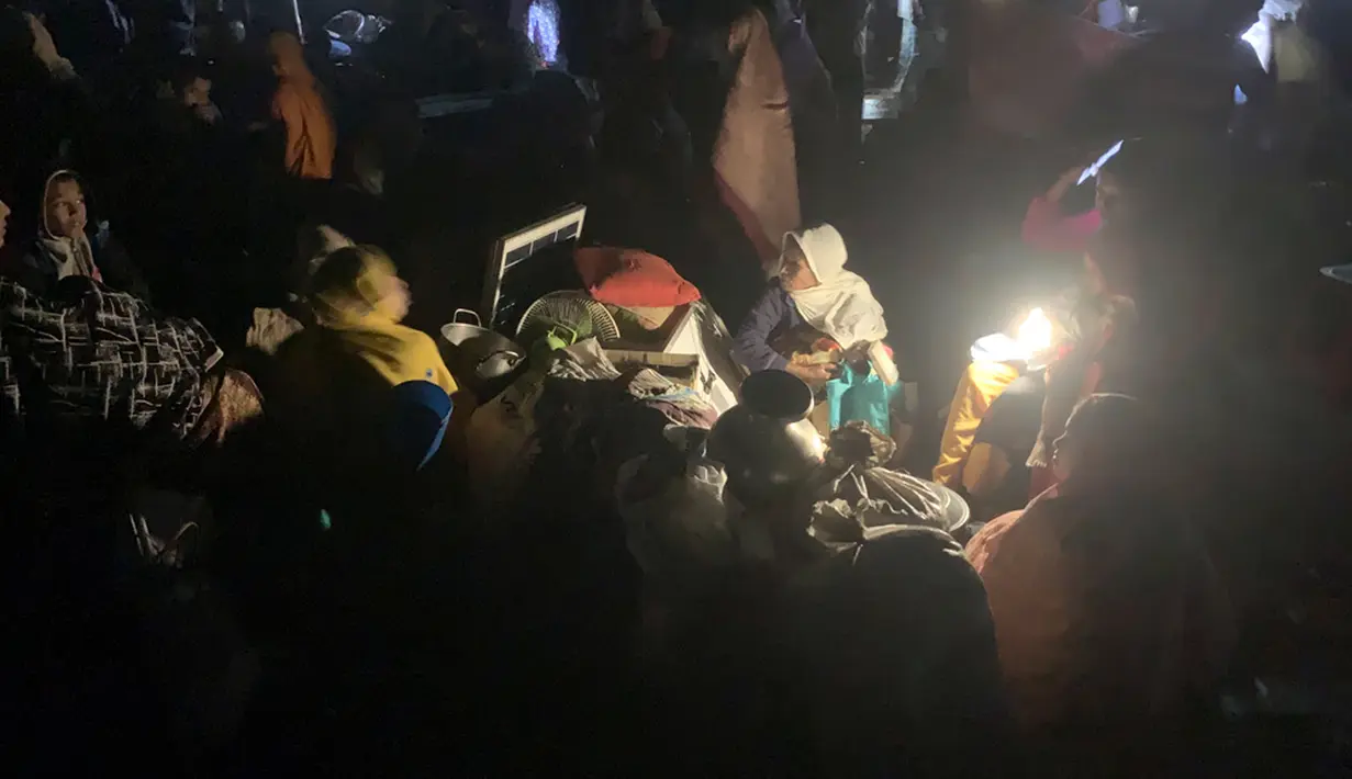 Pengungsi Rohingya duduk di tempat terbuka setelah kebakaran di kamp mereka di Kutupalong. (AP Photo/Shafiqur Rahman)