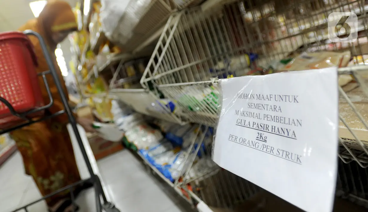 Pembeli berbelanja dekat kertas pemberitahuan pembatasan pembelian gula di supermarket Kawasan Cirendeu, Tangsel, Rabu (18/3/2020). Satgas Pangan meminta pedagang membatasi penjualan bahan pokok yakni beras, gula, minyak goreng dan mi instan, untuk menjaga stabilitas harga. (merdeka.com/Arie Basuki)