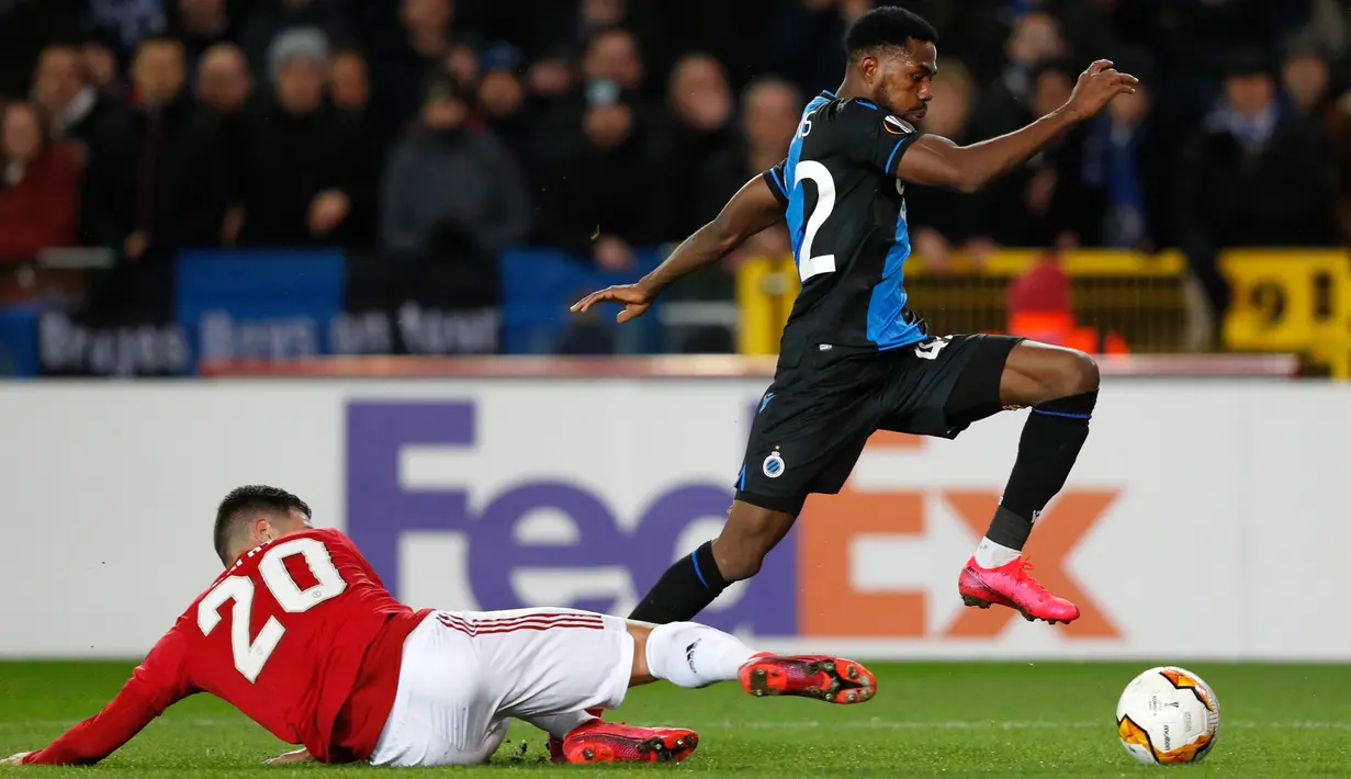 Pemain Club Brugge,  Emmanuel Bonaventure (kanan) berebut bola dengan bek Manchester United, Diogo Dalot dalam leg pertama babak 32 besar Liga Europa di Jan Breydelstadion, Kamis (20/2/2020). Manchester United gagal meraih hasil maksimal usai ditahan imbang Club Brugge 1-1. (JOHN THYS / AFP)