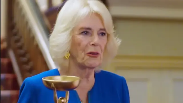Ratu Camilla memegang Piala Iris untuk pemenang Booker Prize.