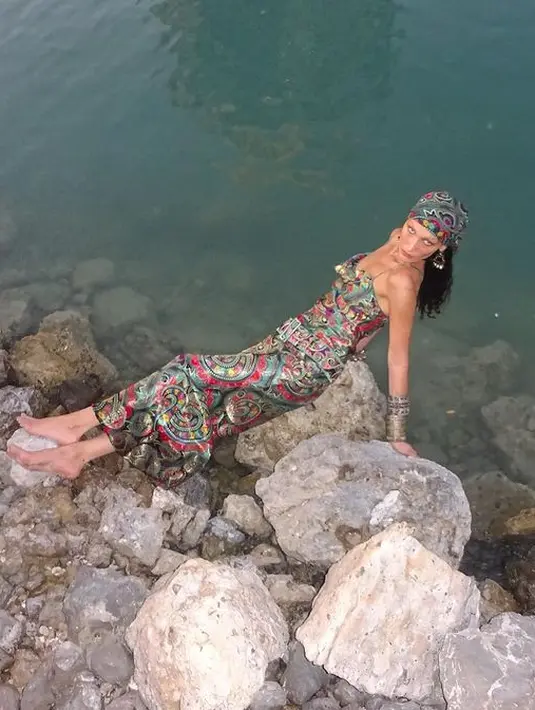 Gaun spagettti strap yang dikenakan Bella Hadid dilengkapi dengan penutup kepala bermotif senada dan aksesori. [instagram/bellahadid]