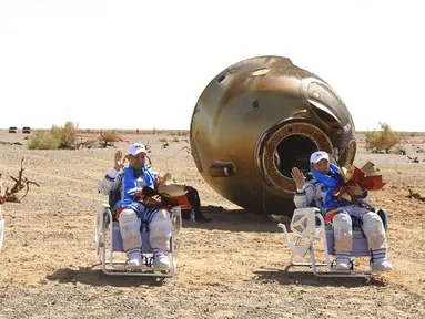 Astronot China Tang Hongbo (kiri), Nie Haisheng (tengah), dan Liu Boming (kanan) melambai di lokasi pendaratan Dongfeng di Daerah Otonomi Mongolia Dalam, China, 17 September 2021. Trio astronot China kembali ke Bumi setelah misi luar angkasa. (Ju Zhenhua/Xinhua via AP)