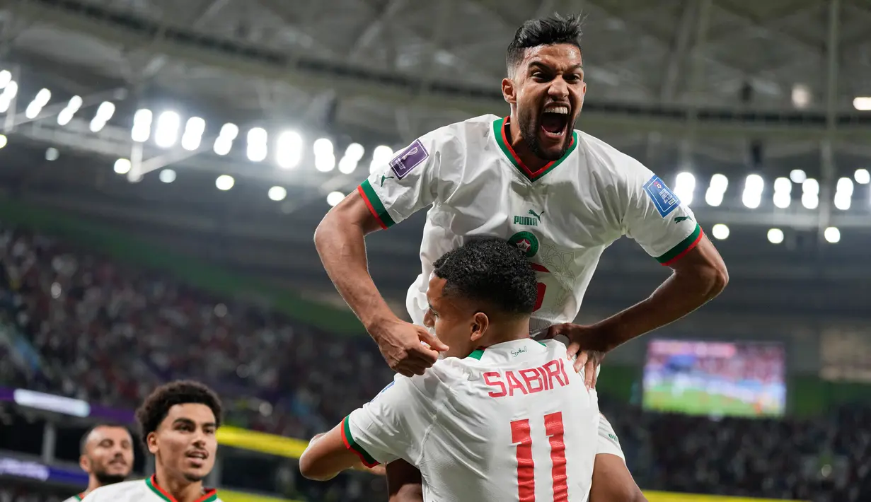 Pemain Maroko Yahya Jabrane (atas) merayakan dengan Abdelhamid Sabiri (11) setelah Sabiri mencetak gol ke gawang Belgia pada pertandingan sepak bola Grup F Piala Dunia 2022 di Stadion Al Thumama, Doha, Qatar, 27 November 2022. Maroko mengalahkan Belgia dengan skor 2-0. (AP Photo/Frank Augstein)