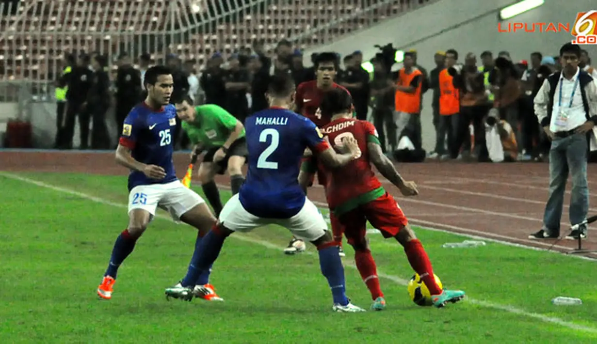 Pemain malaysia, Mahali (tengah) berusaha mengambil bola dari kawalan Pemain Indonesia, Irfan Bachdim (kiri) dalam Laga Piala AFF Suzuki 2012 antara Malaysia vs Indonesia di Stadion Bukit Jalil, Kuala Lumpur, Malaysia. pertandingan berakhir dengan skor 2-