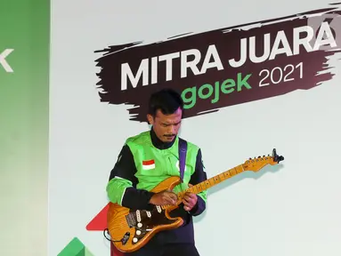 Aksi driver ojol, Mas Bomenn main gitar pada acara Ngobrol Bareng Gojek sekaligus Apresiasi Mitra Juara Gojek di Jakarta, (5/11/2021). Apresiasi diberikan Gojek bagi mitra inspiratif yang terus menunjukkan optimisme, kerja keras, dan ketekunan. (Liputan6.com/Fery Pradolo)