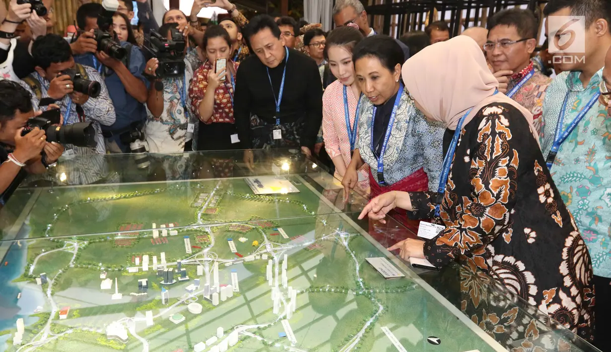 Menteri BUMN Rini Soemarno bersama Kepala Bekraf Triawan Munaf mengunjungi salah satu stand milik perusahaan BUMN selama ajang Pertemuan Tahunan IMF-World Bank Group 2018 di Nusa Dua Bali, Selasa (9/10). (Liputan6.com/Angga Yuniar)