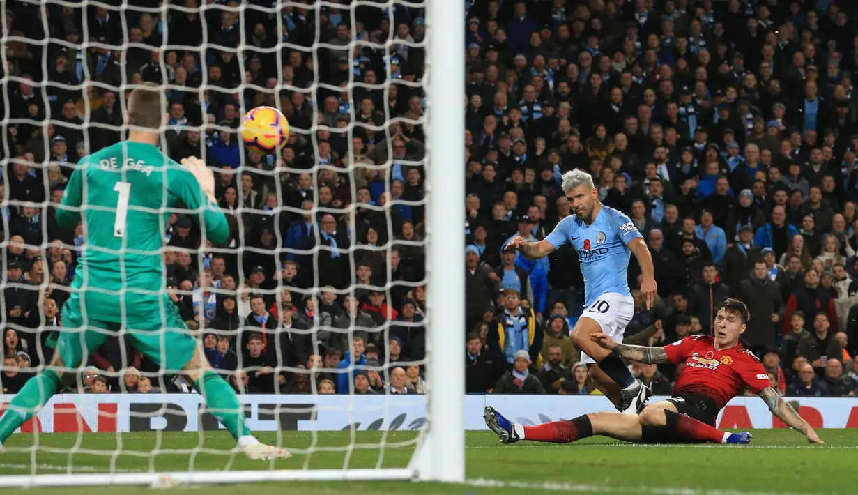 Striker Manchester City, Sergio Aguero melepaskan tendangan ke arah kiper MU, David De Gea saat bertanding pada lanjutan Liga Inggrid di stadion Etihad, Manchester (11/11). Sebelumnya, rambut Aguero berwarna hitam biasa. (AFP Photo/Lindsey Parnaby)