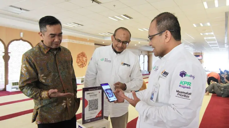 Direktur Operasi Bank Muamalat Indonesia Wahyu Avianto (kanan) didampingi oleh Direktur Kepatuhan Karno (kiri) dan Chief Human Capital Officer Riksa Prakoso (tengah) melakukan donasi menggunakan fitur QR Code pada aplikasi Muamalat DIN