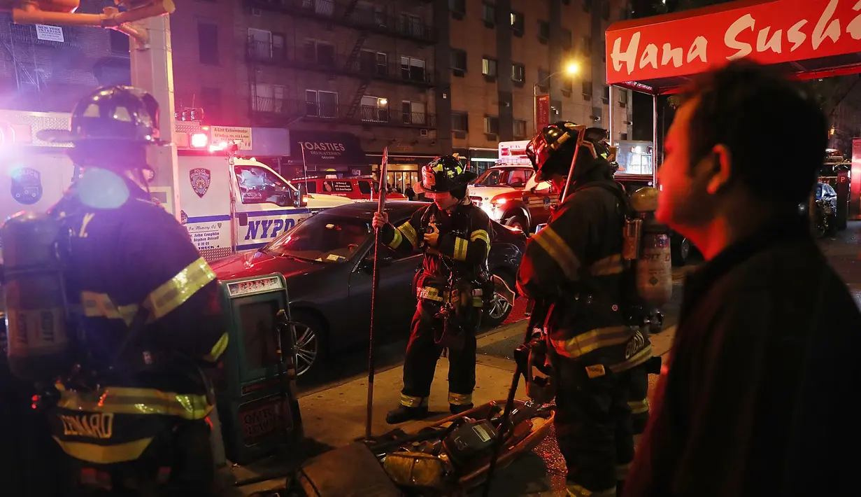 Petugas melakukan penyelidikan di lokasi terjadinya ledakan di New York, Sabtu (17/9). Diduga ledakan terjadi di tempat sampah, menghancurkan jendela gedung yang berada di dekatnya. (AFP PHOTO)