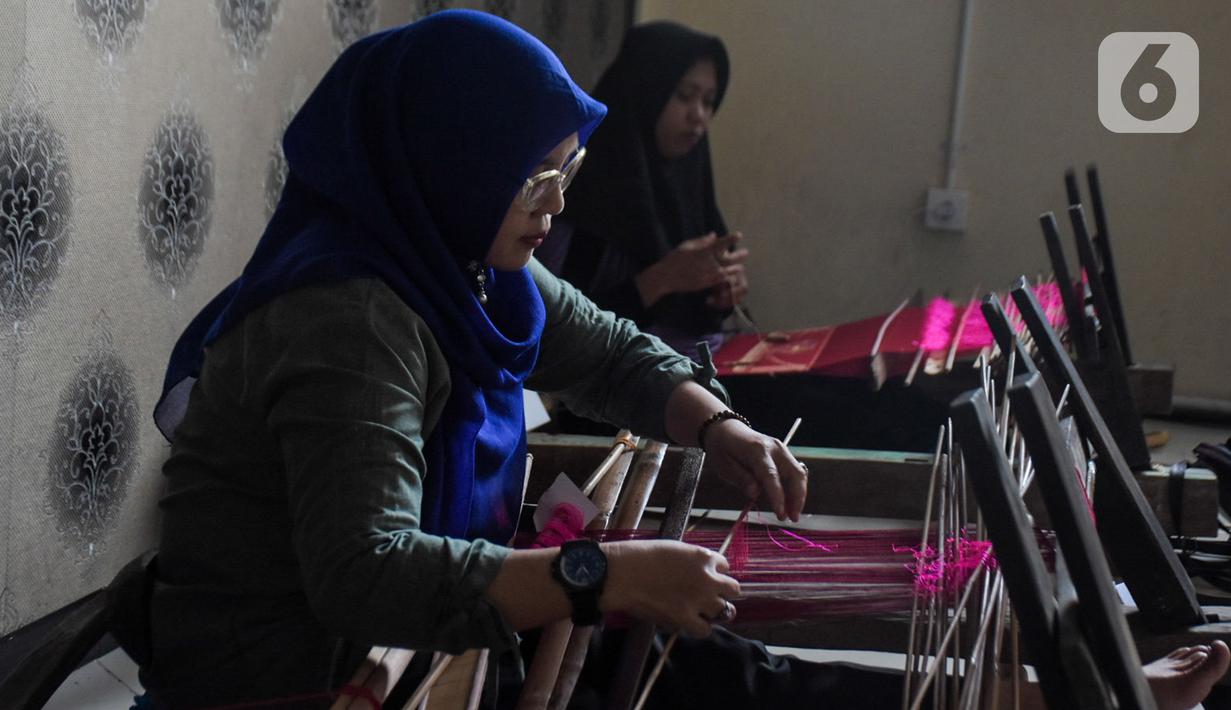 Warga mengikuti pelatihan pembuatan kain tenun motif Betawi di Rusunawa Jatinegara, Jakarta, Rabu (13/11/2019). Pemerintah akan memprioritaskan penyaluran KUR kelompok, seiring dengan diturunkannya suku bunga KUR per 1 Januari 2020 menjadi 6 persen, dari  7 persen. (Liputan6.com/Angga Yuniar)