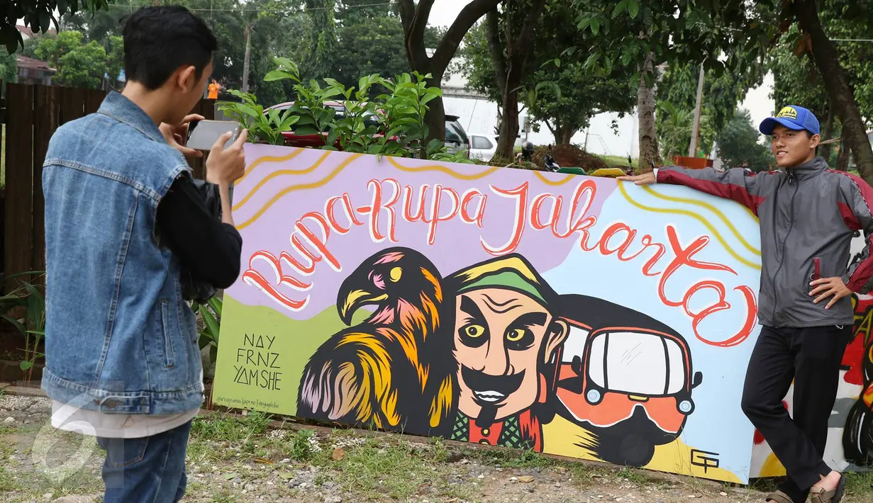 Pengunjung berpose di salah satu lukisan mural saat Festival Budaya Betawi Rupa-Rupa Jakarta di Zona A Setu Babakan, Jakarta, Rabu (14/9). Festival ini menampilkan berbagai kegiatan bernuansa Betawi. (Liputan6.com/Immanuel Antonius)