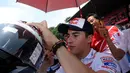Juara Dunia MotoGP 2013 dan 2014, Marc Marquez menandatangi helm salah satu penggemarnya disela-sela acara Meet & Greet di Sirkuit Sentul, Bogor, (21/10/2014). (Liputan6.com/Helmi Fithriansyah)