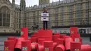 Rishi Sunak dari Oxfam melakukan protes di luar gedung Parlemen di London, Selasa, 19 September 2023. (AP Photo/Kin Cheung)