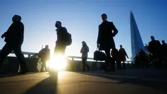 Komuter melintasi London Bridge untuk bekerja menuju kantor di London, Kamis (20/1/2022). Pemerintah Inggris mengakhiri pembatasan COVID-19, termasuk mandat masker, bekerja dari rumah dan paspor vaksin mulai Kamis. (AP Photo/Kirsty Wigglesworth)
