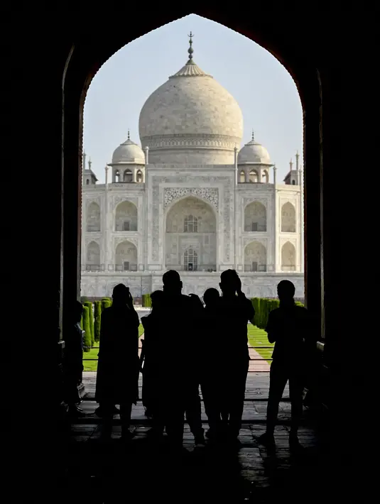Turis mengunjungi Taj Mahal setelah dibuka kembali untuk pengunjung menyusul pelonggaran pembatasan virus corona Covid-19 di Agra, Inida, Rabu (16/6/2021). Taj Mahal ditutup untuk umum pada awal April 2021 ketika India memberlakukan tindakan penguncian ketat. (Money SHARMA/AFP)
