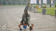 Kopral Bagyo, anggota Polisi Militer Angkatan Darat IV/Surakarta, melakukan aksi jungkir balik mengelilingi tugu Monas, Jakarta, Jumat (17/6). Aksi ini bagian dari kampanye bahaya narkoba dan perayaan ulang tahun ke-70 POM AD (Liputan6.com/Gempur M Surya)