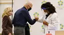 Presiden AS terpilih, Joe Biden melakukan fist bump setelah menerima dosis pertama vaksin virus corona Pfizer-BioNTech di Rumah Sakit Christiana di Newark, Delaware, Senin (21/12/2020). Istrinya, Jill Biden, menerima rangkaian vaksin pertamanya pada hari sebelumnya. (AP Photo/Carolyn Kaster)