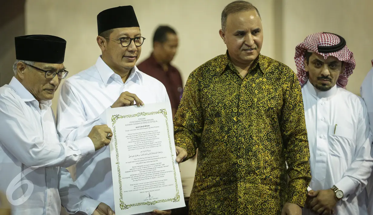 Menag Lukman Hakim Saifuddin menunjukan surat yang usai ditanda tangani saat meresmikan pemajangan potongan Kiswah (kain penutup Kakbah) hadiah dari Raja Salman bin Abdulaziz Al Saud di Masjid Istiqlal, Jakarta, Jumat (10/3). (Liputan6.com/Faizal Fanani)