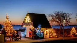 Pohon Natal dan Sinterklas menghiasi pintu masuk pantai di Haffkrug, Jerman utara, Senin (20/12/2021). (AP Photo/Michael Probst)