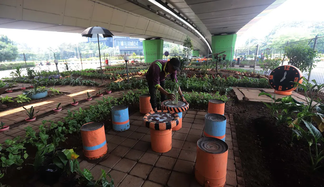 Petugas merawat tanaman taman di kolong fly over Kemayoran, Jakarta,Rabu (11/11/2020). Kolong flyover Kemayoran disulap menjadi ruang terbuka hijau. Ragam tanaman hijau dan kolam ikan menjadikan kawasan ini terlihat sangat asri. (merdeka.com/Imam Buhori)