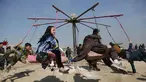 Anak-anak bermain ayunan selama perayaan Nowruz, Tahun Baru Persia, di Kabul, Afghanistan, (21/3). Nowruz dirayakan pada hari pertama musim semi di negara-negara termasuk Afghanistan, Tajikistan, dan Iran. (AP Photo/Rahmat Gul)