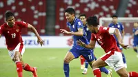 Pemain Thailand, Bordin Phala (tengah), diapit dua penggawa Timnas Indonesia saat bertanding pada leg pertama final Piala AFF 2020 di National Stadium, Singapura, Rabu (29/12/2021) malam WIB. (AP Photo/Suhaimi Abdullah)