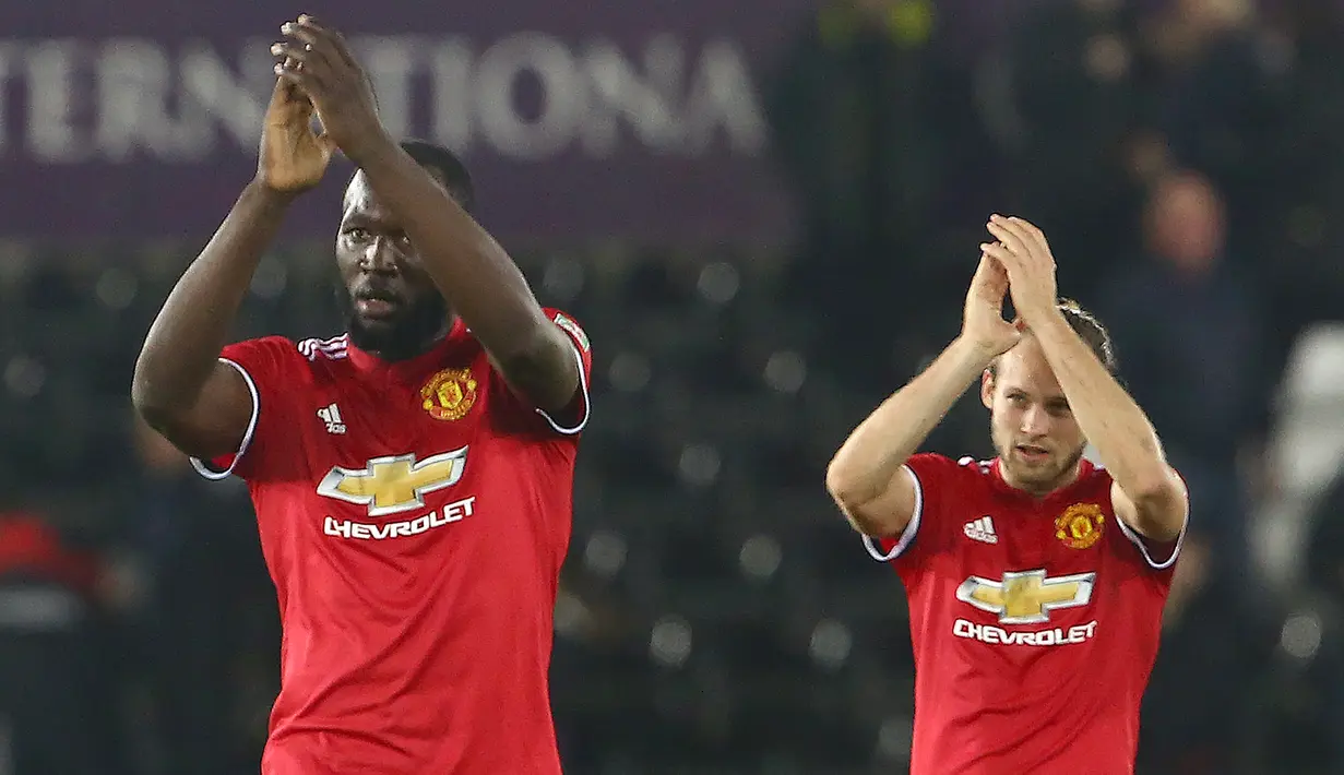 Pemain Manchester United, Romelu Lukaku dan Daley Blind bertepuk tangan ke arah suporter seusai pertandingan Piala Liga Inggris melawan Swansea City di Liberty Stadium, Rabu (25/10). MU sukses menekuk Swansea City dengan skor 2-0. (GEOFF CADDICK/AFP)