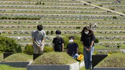 Anggota keluarga memberi penghormatan kepada pemakaman leluhur mereka menjelang liburan Chuseok di sebuah pemakaman di Paju, Korea Selatan (12/9/2021).  Penutupan pemakaman selama lima hari dari 18 September hingga 22 September untuk mencegah penyebaran virus corona. (AP Photo/Ahn Young-joon)