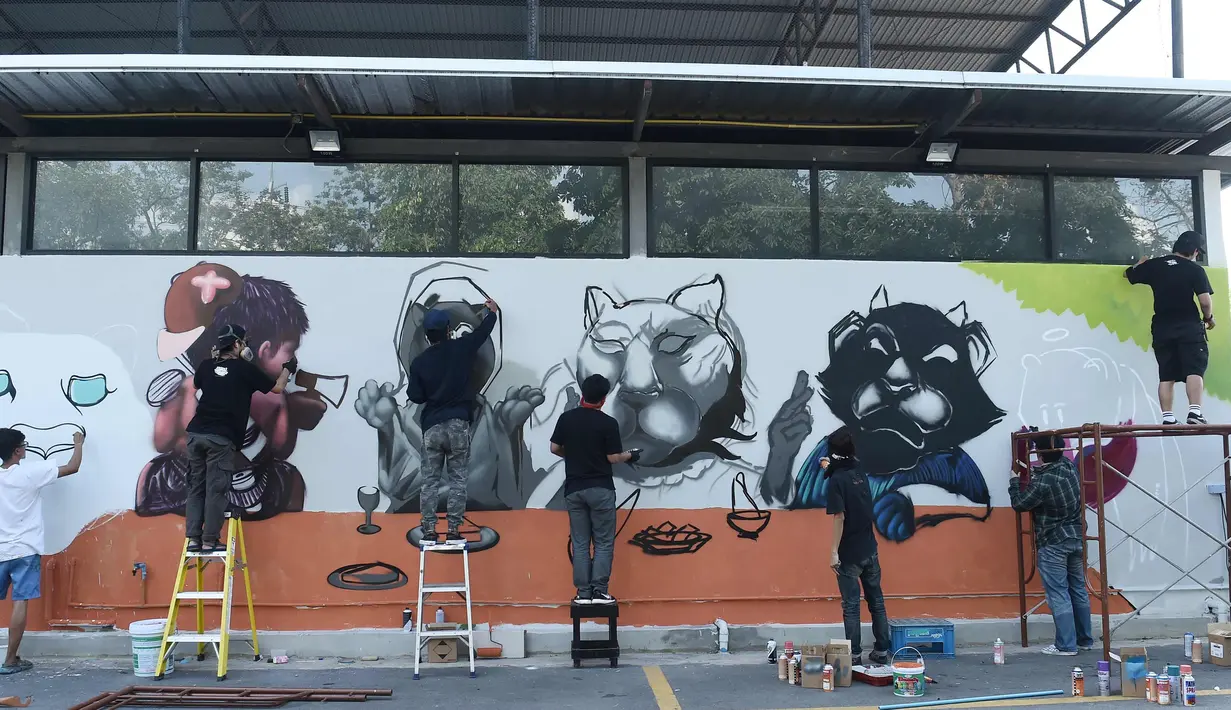 Sejumlah seniman grafiti membuat mural harimau kumbang di Bangkok, Thailand (16/3). Aksi ini sebagai protes perburuan liar ilegal oleh konglomerat konstruksi Premchai Karnasuta. (AFP Photo/Lillian Suwanrumpha)