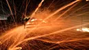 Bara api dari kebakaran hutan tertiup angin kencang di daerah sekitar kota Nowra, kota Nowra, negara bagian New South Wales, Australia, Selasa (31/12/2019). Akibat kebakaran ini, ribuan wisatawan dan penduduk lokal mengungsi ke wilayah pantai di Australia tenggara. (AFP/Saeed Khan)