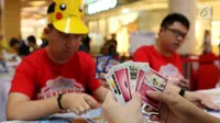 Para pecinta kartu pokemon bermain kartu The Pokémon Trading Card Game di  Kota Kasablanca, Jakarta, Kamis (8/8/2019). Di pasar global, permainan tukar kartu itu telah terjual sebanyak 27,2 miliar kartu hingga Maret 2019 dengan segmentasi anak-anak hingga dewasa. (Liputan6.com/Angga Yuniar)