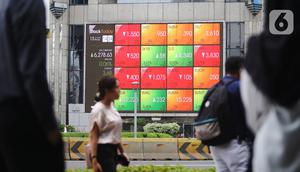 Pejalan kaki melintas dekat layar pergerakan Indeks Harga Saham Gabungan (IHSG) di kawasan Jakarta, Senin (13/1/2020). IHSG sore ini ditutup di zona hijau pada level 6.296 naik 21,62 poin atau 0,34 persen. (Liputan6.com/Angga Yuniar)