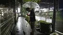 Suami istri berdoa untuk para korban setelah meletakkan bunga di luar gedung Kyoto Animation Studio di Kyoto, Jepang (19/7/2019). Stasiun televisi NHK melapor, seorang pria yang menuangkan bensin ke sekitar gedung animasi telah ditahan. (AP Photo/Jae C. Hong)
