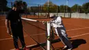 Artyn Elmayan melakukan pemanasan jelang bermain tenis di River Plate Club di Buenos Aires, Selasa (16/5). Meski usianya telah mencapai 100 tahun, Artyn mengaku tetap rutin main tenis tiga kali seminggu. (AFP FOTO / Eitan ABRAMOVICH)