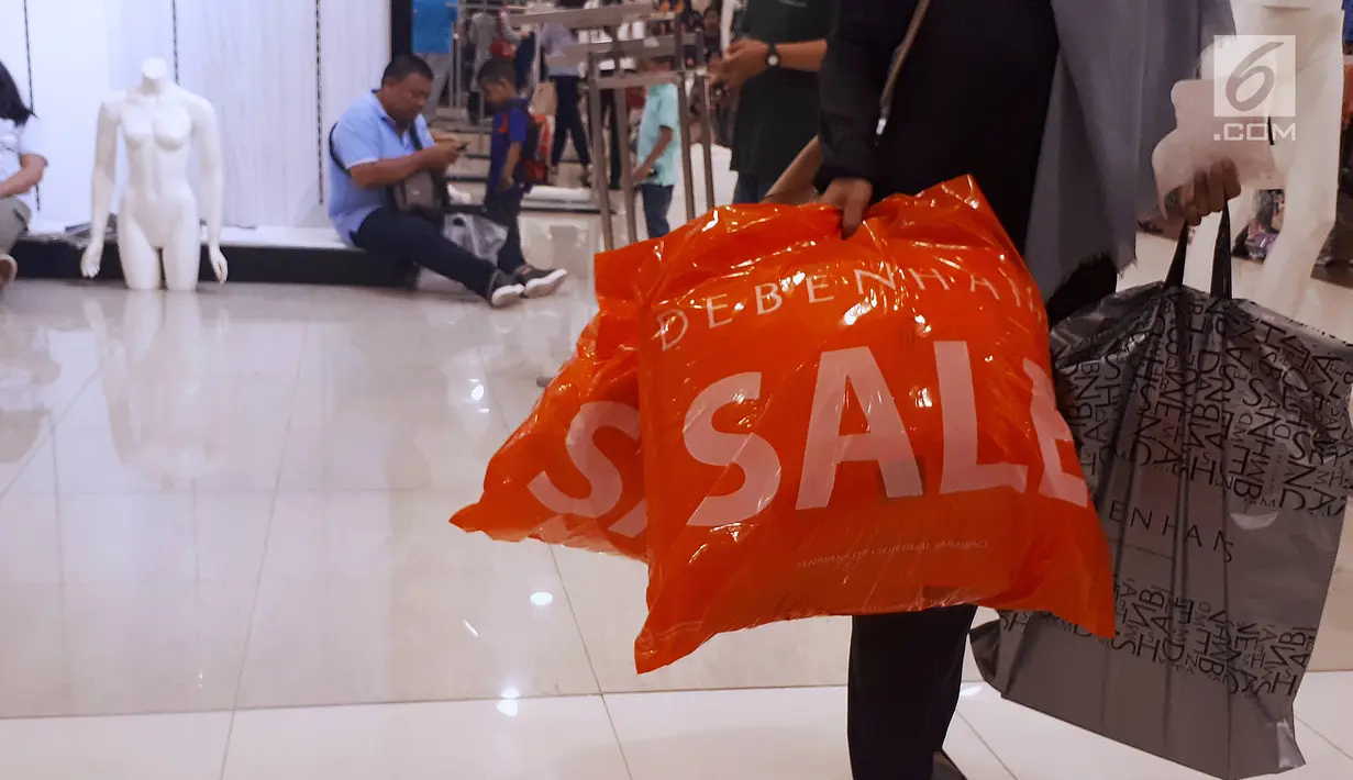Pembeli membawa belanjaan saat midnight sale di gerai Debenhams, Senayan City, Jakarta, Sabtu (30/12). Tutupnya gerai Debenhams karena perubahan gaya berbelanja masyarakat. (Liputan6.com/Fery Pradolo)