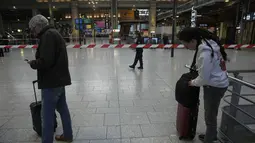 Pelancong ada di balik pita polisi di stasiun kereta Gare du Nord, Paris, Rabu (11/1/2023). Pria tersebut ditangkap oleh polisi di stasiun tersebut setelah mereka melepaskan tembakan dan melukainya, kata sumber polisi, yang meminta untuk tidak disebut namanya. (AP Photo/Michel Euler)