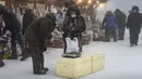 Orang-orang membeli ikan beku di pasar jalanan saat suhu turun hingga sekitar minus 50 derajat Celcius (-58 derajat Fahrenheit) di Yakutsk, Rusia, Sabtu (16/1/2021).  Yakutsk atau Yakutia tersohor sebagai kota terdingin di dunia. (AP Photo/Tatiana Gasich)