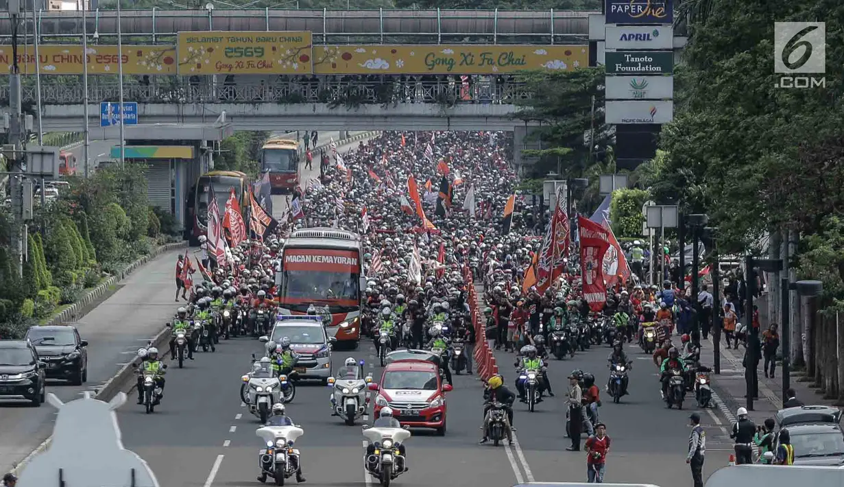 Bus yang membawa pemain Persija, pelatih dan ofisial tim memimpin Pawai Juara Piala Presiden 2018 di kawasan Sudirman, Jakarta, Minggu (18/2). Konvoi arak-arakan dimulai dari Stadion Utama Gelora Bung Karno menuju Balai Kota. (Liputan6.com/Faizal Fanani)