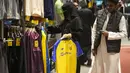 Seorang wanita memegang kaus Cristiano Ronaldo di toko klub Al Nassr di Riyadh, Arab Saudi, Senin, 2 Januari 2023. Antusiasme suporter berburu jersey sang megabintang dari Portugal itu membuat pemasukan tim bertambah. (AP Photo/Amr Nabil)