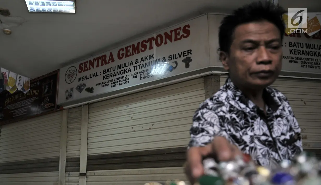 Pengunjung melihat koleksi batu akik di salah satu kios yang masih bertahan di Pasar Rawa Bening, Jakarta, Senin (10/9). Sepinya pembeli menyebabkan banyak kios pedagang batu akik tutup akibat gulung tikar. (Merdeka.com/Iqbal S. Nugroho)