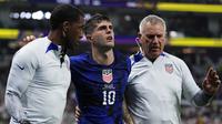 Pemain timnas Amerika Serikat, Christian Pulisic (tengah) dibantu tim medis untuk kembali ke lapangan usai menjebol gawang Iran dalam pertandingan grup B Piala Dunia 2022 yang berlangsung di Al Thumama Stadium, Doha, Qatar, Rabu (30/11/2022). (AP Photo/Manu Fernandez)
